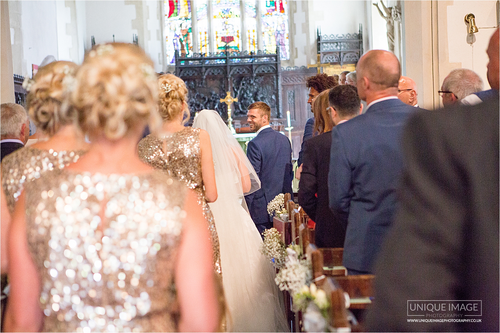 bride walks down the aisle to meet her groom