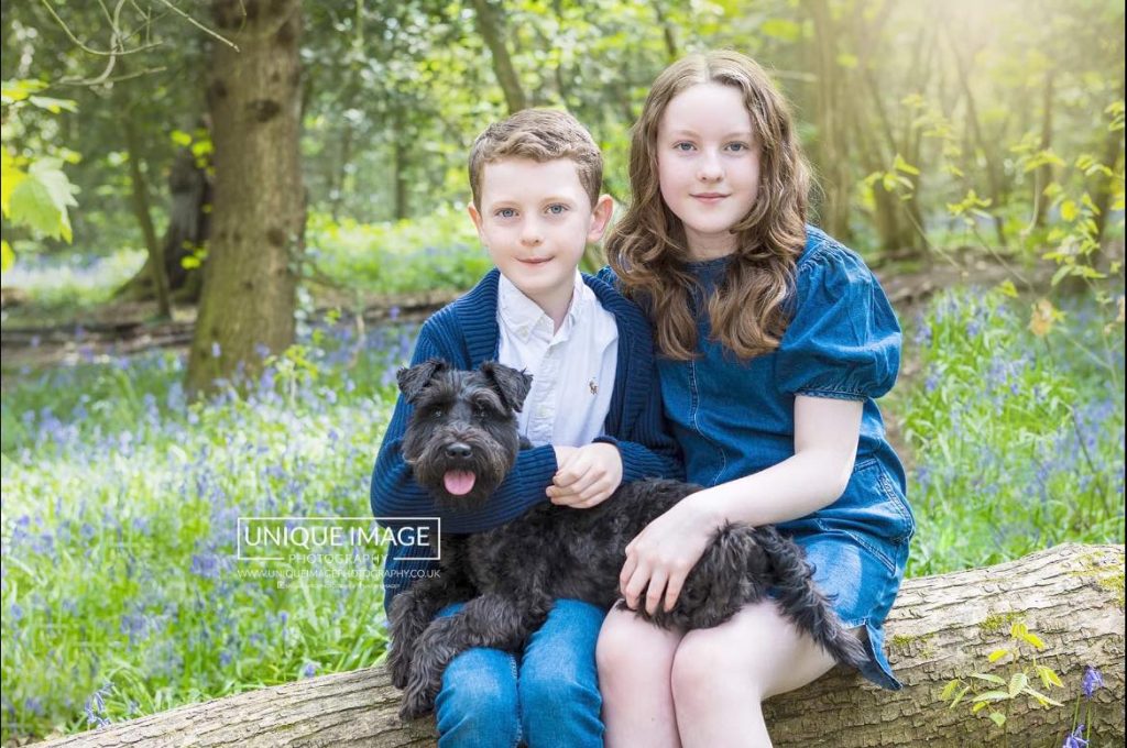 children and puppy in the bluebells